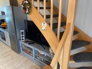 een woonkamer met een trap en een televisie bij Domek wakacyjny in Pogorzelica