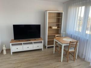 a living room with a tv and a table with a dining room at Krasickiego 12 Gdynia Centrum in Gdynia