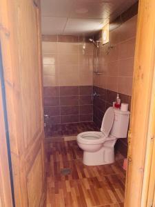 a bathroom with a toilet and a tiled floor at WADI RUM-Bedouin Tents and Jeep Tours in Wadi Rum