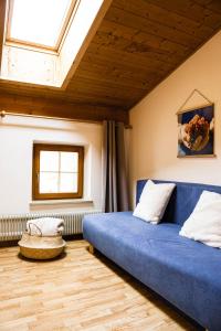 - une chambre avec un lit bleu et une fenêtre dans l'établissement Töllhof Apartments and Farm, à Naz-Sciaves
