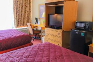 a hotel room with a bed and a television at Howard Johnson by Wyndham Atlanta Airport in Atlanta