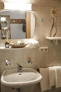 La salle de bains est pourvue d'un lavabo, d'un miroir et de serviettes. dans l'établissement Töllhof Apartments and Farm, à Naz-Sciaves