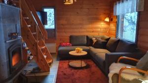 a living room with a couch in a log cabin at Vuosselintähti 8 B in Ruka