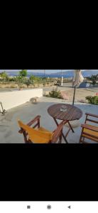 a wooden table and chairs on the beach at ONAR STUDIOS MILOS Junior in Adamantas