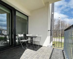 a patio with a table and chairs on a balcony at Centre Apartment in Druskininkai