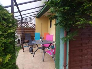 un patio con mesa y sillas coloridas en Domek na Zaciszu en Rowy