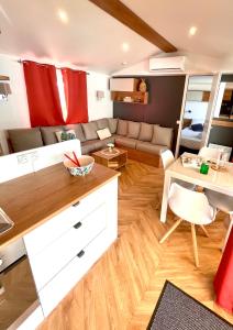 ein Wohnzimmer mit Couch und Tisch in der Unterkunft Mobil-home tout beau tout neuf, camping 4*, plage à pied ! in Canet-en-Roussillon