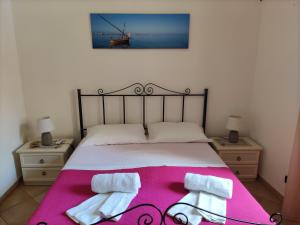 a bedroom with a bed with two towels on it at L'Azzurro Apartment in Valderice