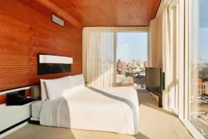 a bedroom with a white bed and a large window at The Standard, High Line New York in New York