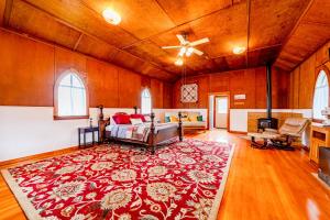 a large room with a bed and a red rug at Gateway Cottage in Orick