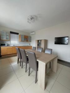 een keuken en eetkamer met een houten tafel en stoelen bij Appartement MB - Logement 3 chambres - Drage in Drage