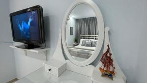 een witte kamer met een televisie en een spiegel bij Nest for rest in Karpathos