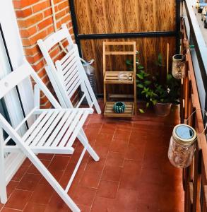 two white chairs sitting on a porch at Estepeña in Talavera de la Reina