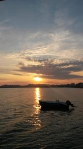 a boat in the water with the sunset in the background at SANDY Blue Sea in Durrës