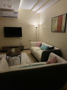 sala de estar con 2 sofás y TV de pantalla plana en شقق مفروشه خاصه بالطائف, en Taif