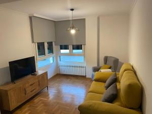 a living room with a couch and a flat screen tv at Apartamento Turistico Valdellera IV in Posada de Llanes