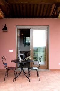 einen Tisch und Stühle in einem Zimmer mit Fenster in der Unterkunft Agriturismo L'Aquilone in Magliano in Toscana