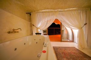 uma banheira branca na casa de banho com uma janela em Fairyland Cave Hotel em Goreme