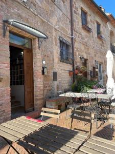 patio ze stołem i krzesłami przed budynkiem w obiekcie I Ricordi w mieście Sovana