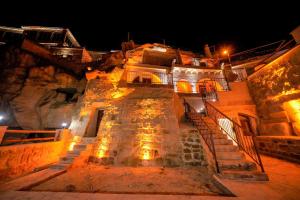 um edifício de pedra com escadas e luzes à noite em Fairyland Cave Hotel em Goreme