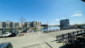 ApartmentInCopenhagen Apartment 1487 في كوبنهاغن: مجموعة من الدراجات متوقفة على رصيف جانبي بجوار نهر
