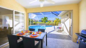 a dining room with a table and a pool at !NEW! Villa Violina in Cape Coral