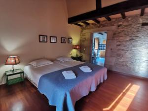 a bedroom with a bed and a stone wall at Casa do Peto in A Bana