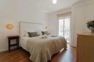 un dormitorio con una cama con dos animales de peluche en O&L Murillo Bright apartment - terrace & parking en Sevilla