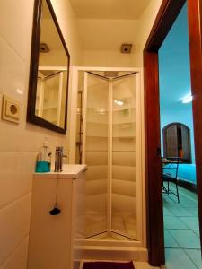 y baño con ducha, lavabo y espejo. en Centro de Arte, en Yunquera