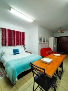 - une chambre avec un lit et une table en bois dans l'établissement Centro de Arte, à Yunquera