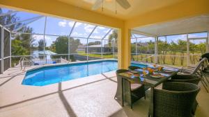 un patio con una mesa y una piscina en !NEW! Villa Sunshine private Pool en Cape Coral