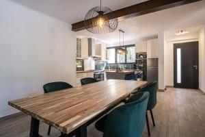 een keuken met een houten tafel en stoelen bij Maison idéale pour les familles avec piscine privée - Fontaine-de-Vaucluse in Fontaine-de-Vaucluse