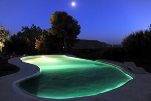 una grande piscina verde di notte di Propriété avec vues panoramiques a Cabrières-dʼAvignon