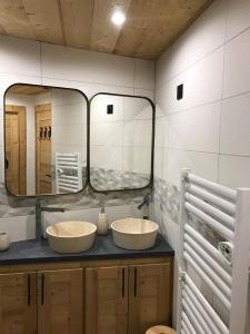 a bathroom with two sinks and a large mirror at Cocoonabay Appartements in Les Angles +19 photos