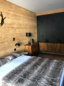 レ・ザングルにあるCocoonabay Appartementsの木製の壁のベッドルーム1室(ベッド1台付)