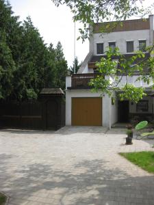 una casa con garaje frente a una entrada en Rent a Scooter Vendégház, en Zamárdi
