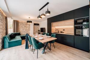 kuchnia i jadalnia ze stołem i zielonymi krzesłami w obiekcie Casa Giulia with heated pool w mieście Privlaka
