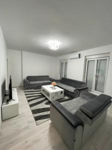 a living room with two couches and a tv at Modern & cozy 2-bedroom vacation home in Sarajevo in Sarajevo