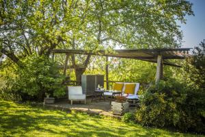 a patio with a table and chairs under a wooden pergola at casina MeMe in Pescia