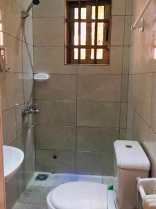 a bathroom with a shower and a toilet and a sink at Villa Cocotiers A11 in Cotonou