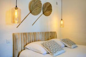 a bedroom with a bed with two pillows and two lights at Le Bercail de Montmirail in Sarrians