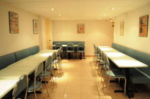 une rangée de tables et de chaises dans un restaurant dans l'établissement Hipotel Paris Printania Maraichers, à Paris