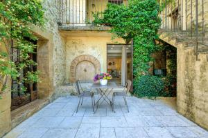 a patio with a table and chairs in a building at Le Bercail de Montmirail in Sarrians