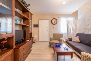 un salon avec un canapé et une télévision dans l'établissement Casa Helen, à SantʼAntìoco
