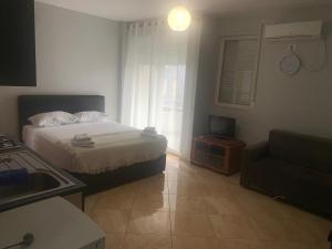 a small bedroom with a bed and a couch at Kokomani in Durrës