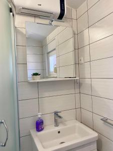 a bathroom with a sink and a mirror at Apartman Ritta in Biograd na Moru