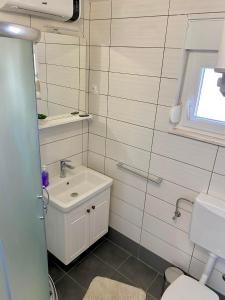 a bathroom with a sink and a toilet at Apartman Ritta in Biograd na Moru