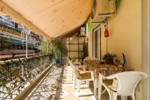 - une terrasse avec une table et des chaises dans un bâtiment dans l'établissement Bright,Comfort House in the heart of Athens, à Athènes