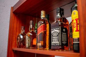 a shelf with several bottles of alcohol on it at Résidence Hôtelière Lauria in Lomé