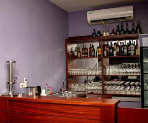 a bar with a counter and a shelf of alcohol bottles at Résidence Hôtelière Lauria in Lomé